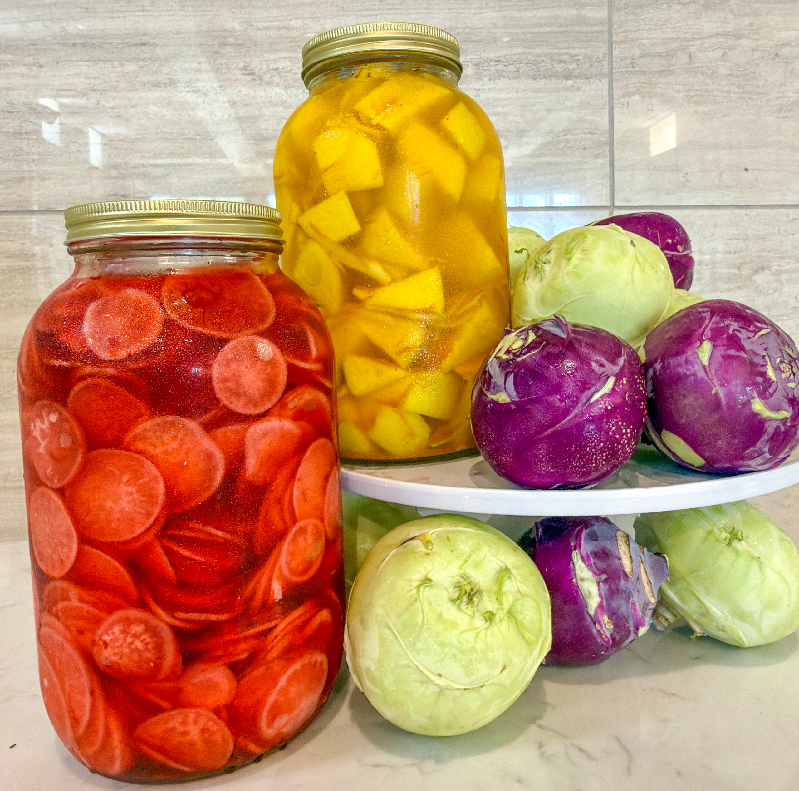 Colorful jars of pickles are arrayed with purple and white kohlrabi.