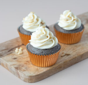 blue corn cupcakes with piped white icing on a wooden board
