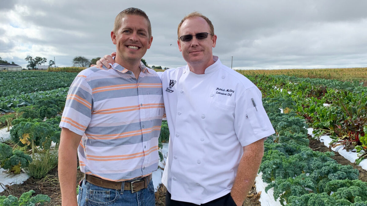 Chef poses with farmer in field