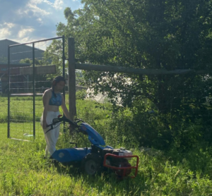 student using walk behind tractor 
