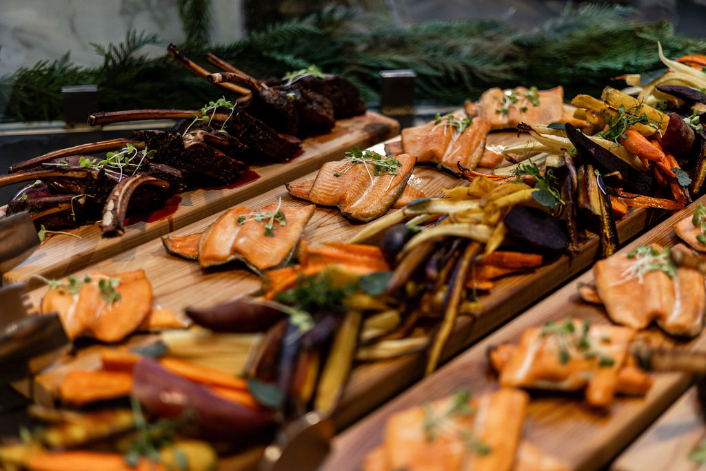 Planks of roasted vegetables, smoked trout, and elk on display. 