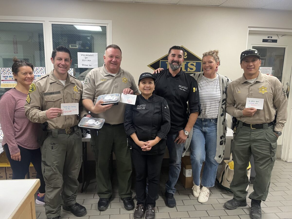 A group of public officials and culinary professionals stand together smiling.